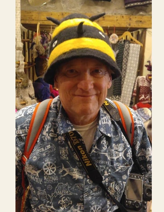 A man in a bumble bee hat with his camera - the photograph, and the modern portrait painted from it