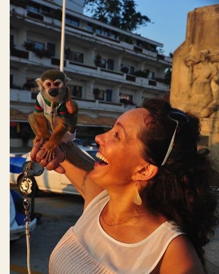A woman laughing with a monkey on her hand - the photograph, and the watercolour painted from it